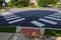 White rectangular intermittent crosswalk markers painted on the asphalt road in a residential neighborhood Royalty Free Stock Photo