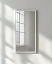 Sunlight Reflecting in a White Framed Mirror on a Textured Wall Royalty Free Stock Photo