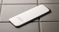 White rectangular object on gray tiled surface. The item has Royalty Free Stock Photo