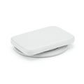A white rectangular object with rounded edges rests on a circular base