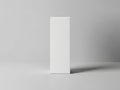 A white rectangular object stands upright on a plain gray surface with subtle shadow Royalty Free Stock Photo