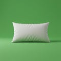 A white rectangular pillow is placed against a solid green background. The pillow Royalty Free Stock Photo