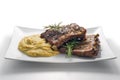 White rectangular plate with baked pork ribs and cornmeal mush Royalty Free Stock Photo