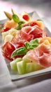 Artfully Arranged Cantaloupe And Honeydew Melon Slices With Prosciutto Ham And Fresh Basil Garnish Royalty Free Stock Photo