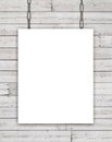 White rectangular poster hanging on chain over wooden background