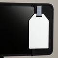 A white, rectangular pricing tag with a gray loop is attached to a black object, possibly Royalty Free Stock Photo