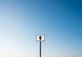 White rectangular sign with a black upward arrow, mounted on a Royalty Free Stock Photo