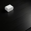 White rectangular speaker with rounded edges on a dark wood grain table. The spea Royalty Free Stock Photo