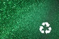 White recycle sign and green glitter lights background. defocused lights.