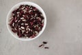 White and red beans in a white bowl on a gray background. Beans are a healthy, tasty and satisfying product