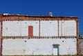 A white and red brick wall against a blue sky.