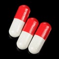 White And Red Capsules on Black Background Royalty Free Stock Photo