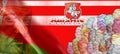 White-red flag of Belarus with the chase coat of arms on a red background. In the background, a portrait of Lukashenka