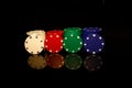 White, red, green, blue pocker chips stack with four  chips in front isolated on black with reflection Royalty Free Stock Photo