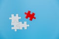 White and red jigsaw puzzle on a blue background. Copy space for text, top view, close up Royalty Free Stock Photo