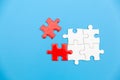 White and red jigsaw puzzle on a blue background. Copy space for text, top view, close up Royalty Free Stock Photo