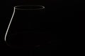 White and red linear silhouette of wine glass bowl on black.