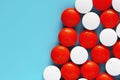 White and red medicine pills on blue background. Top view, copy space Royalty Free Stock Photo