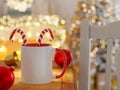 White and Red Mug Mock Up with Bright Background Lights Unfocused in a Christmas Scene