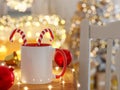 White and Red Ceramic Mug with Bright Lights Unfocused and Christmas Decorations Royalty Free Stock Photo