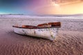 A white and red painted wooden fishing boat on the Paternoster beach in South Africa