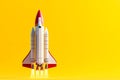 A red and white rocket taking off from a yellow background Royalty Free Stock Photo