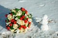 White and red rose wedding bouquet in in the snow and wedding rings on a snowman Royalty Free Stock Photo