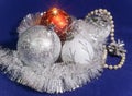 White, red and silver glass New Year`s balls, brilliant tinsel, cones and a pearl beads on a blue background - New Year`s composit Royalty Free Stock Photo