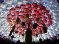 White and red umbrellas above the head and tree, sidewalk between plants and blooming flowers in Miracle garden, Dubai