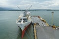 White refrigerated cargo ship moored in port of Puerto Barrios. Reefer vessel is older style bulk vessel with derricks.