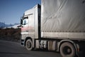 White refrigerated truck on winter road on background of the mountains