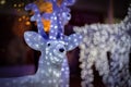 A white reindeer made of LED lights stands at a Christmas market. Royalty Free Stock Photo