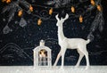 White reindeer on wooden table over chalkboard background with hand drawn chalk illustrations. Royalty Free Stock Photo