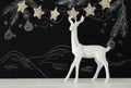 White reindeer on wooden table over chalkboard background whith hand drawn chalk illustrations. Royalty Free Stock Photo