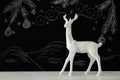 White reindeer on wooden table over chalkboard background whith hand drawn chalk illustrations. Royalty Free Stock Photo