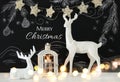 White reindeer on wooden table over chalkboard background whith hand drawn chalk illustrations Royalty Free Stock Photo