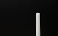 White religious candle on a black background
