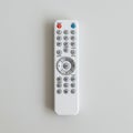 White remote control on a light surface, featuring numerous buttons arranged in rows Royalty Free Stock Photo