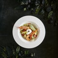 White Restaurant Plate of Caesar Salad with Shrimps, Chicken, Croutons, Tomatoes, Cucumbers Top View Royalty Free Stock Photo