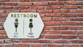 White restroom sign on bricked wall. Royalty Free Stock Photo