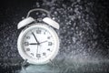 White retro alarm clock in a black background under the water drops.. Morning. Break. Motivation. Business solutions. Success. Royalty Free Stock Photo