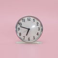 A white retro alarm clock without an external bell. isolated on pink background. Square format Royalty Free Stock Photo