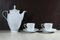 White retro coffee or tea pot with cups on dark background Royalty Free Stock Photo