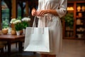 White reusable shopper bag in the hands of a woman with a copy space for logo application, mockup