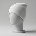 A white, ribbed knit beanie is displayed on a simplistic, featureless mannequin head. Royalty Free Stock Photo