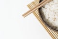 White rice in a coconut bowl on a white background. Minimalistic photo with rice and bamboo chopsticks Royalty Free Stock Photo