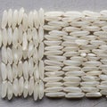 White rice grains are arranged neatly in two sections on a textured gray surface. The left section Royalty Free Stock Photo