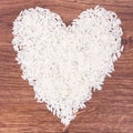 White rice in shape of heart on rustic board, healthy nutrition Royalty Free Stock Photo