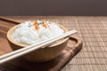 White rice in wooden bowl and chopsticks with sesame seeds and carrot on wood board Royalty Free Stock Photo