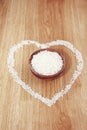 White rice in a wooden plate and rice pattern in the shape of a heart Royalty Free Stock Photo